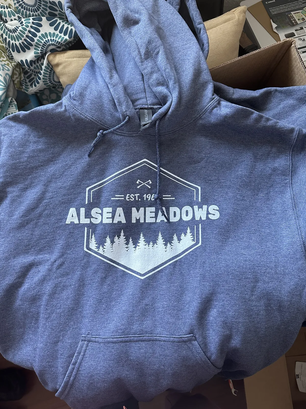 Blue hoodie printed with the Alsea Meadows logo