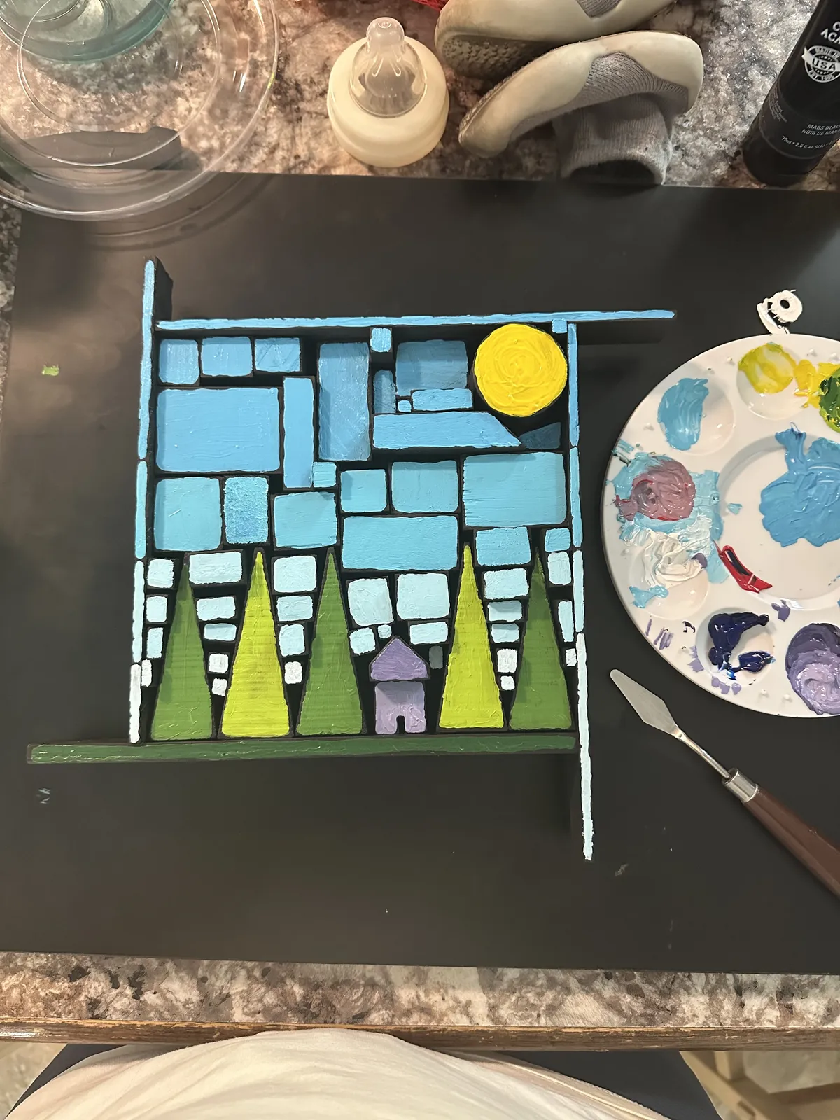 Painting the sky and trees with a palette nearby