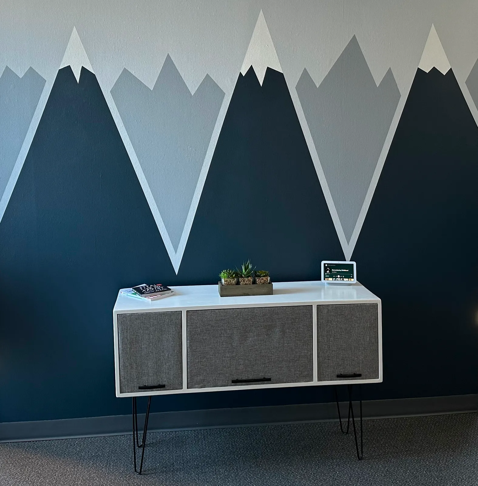 White speaker cabinet on hairpin legs with gray fabric doors